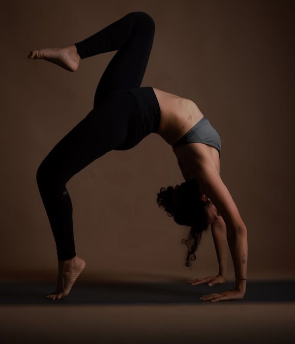 Woman in a calm yoga pose against a dark background with lime accents.